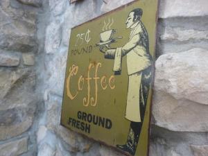 a sign on a wall with a man holding a cake at Liolà in Modica