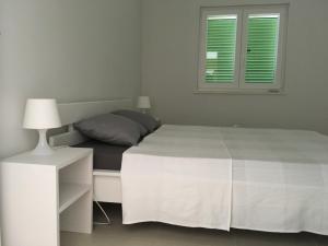 a white bedroom with a bed and a window at Villa Kvarner in Šilo +39 photos