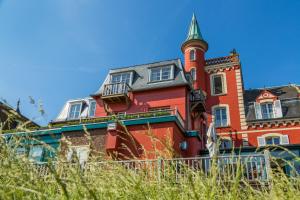 a red brick building with a tower on top of it at Hotel Restaurant Les Tourelles in Le Crotoy +12 photos