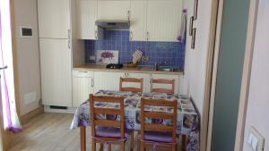 a kitchen with a table and chairs and a sink at Casa Papaveri Rossi in Finale Ligure