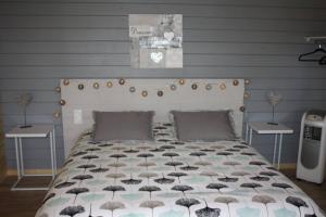 um quarto com uma cama com um edredão preto e branco em Chambres d'hôtes la landrière em Mauléon