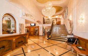 un hall avec un escalier et un lustre dans l'établissement Hotel Oswald, à Selva di Val Gardena