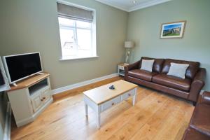 a living room with a couch and a coffee table at Llys y Barnwr - Judge's Court in Aberystwyth