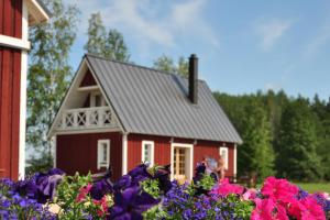 una casa roja con flores delante en Põnka Guesthouse, en Jõesuu