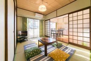 ein kleines Wohnzimmer mit einem Tisch und Stühlen in der Unterkunft Simple Stay Beppu in Beppu