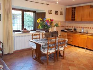 uma cozinha com uma mesa com cadeiras e uma mesa e uma mesa e uma cozinha em Il Mulino in Maremma em Farnese