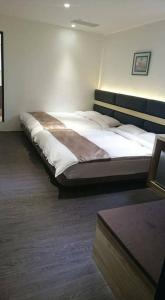 a bedroom with a large bed in a room at Happy Hotel in Lugang