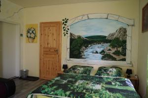 Schlafzimmer mit einem Bett mit Wandgemälde in der Unterkunft Pension Mona Lisa in Braunlage