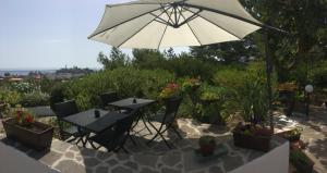 une terrasse avec une table et un parasol dans l'établissement Costa Residence Vacanze, à Lipari