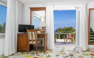 a home office with a desk and a sliding glass door at Hotel Bellavista in Anacapri