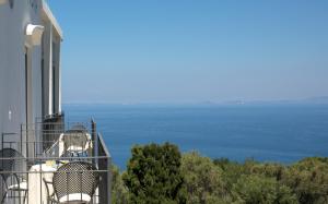 a balcony of a house with chairs and the ocean at Hotel Bellavista in Anacapri