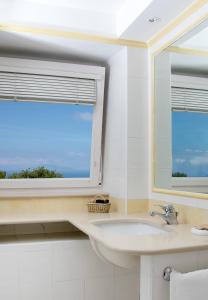 a white bathroom with a sink and a window at Hotel Bellavista in Anacapri