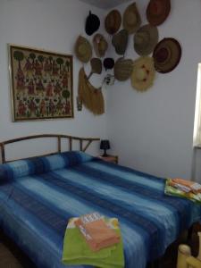 een slaapkamer met een bed met hoeden aan de muur bij Resort Luna Rossa in Sperlonga