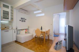a kitchen and a living room with a table and a couch at Apartment Lana in Split