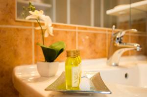 - une bouteille d'huile sur un lavabo avec une fleur dans l'établissement Apartment Lana, à Split