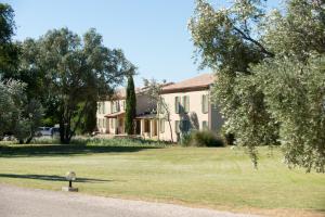 une grande maison avec une grande pelouse devant elle dans l'établissement Best Western Hôtel Aurélia, à Maussane-les-Alpilles