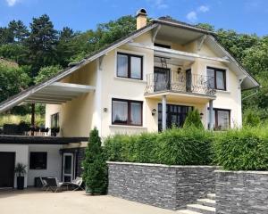 una gran casa blanca con una pared de piedra delante de ella en Apartmán Amália en Banská Bystrica