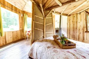 een slaapkamer met een bed in een kamer met houten wanden bij La Clairière du Verbamont in Claudon