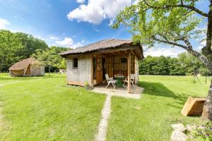 een kleine hut met een grasdak op een veld bij La Clairière du Verbamont in Claudon