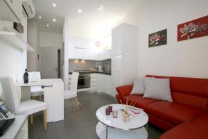 a living room with a red couch and a table at Bonnes Vacances a Pietrasanta in Pietrasanta