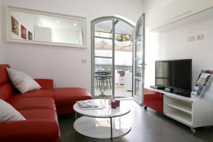 a living room with a red couch and a tv at Bonnes Vacances a Pietrasanta in Pietrasanta