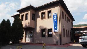 a building with a blue sign on the side of it at Guest house DON-lux in Pljevlja