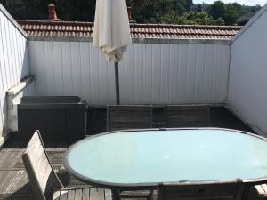 a bath tub on a deck with a table and chairs at la grange in Jeuxey