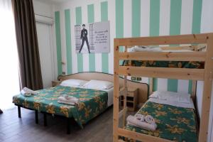 2 letti a castello in una piccola camera con un letto e un letto a castello di Beach Hotel Clerice a Rimini