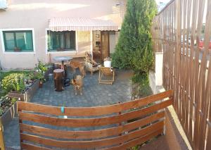 a patio with a fence and two dogs standing on it at Favela Hostel in Zagreb