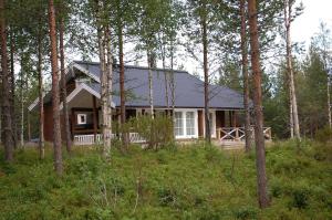 una casa en medio de un bosque con árboles en RukaNeliö Cottage, en Ruka