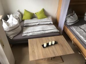Habitación con sofá con almohadas y mesa. en schwarzwald-apartment, en Schönwald 28 fotos más