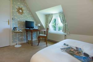 a bedroom with a bed and a desk with a computer at Chateau de la Rozelle in Cellettes