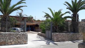 レウカにあるPietra del Mediterraneoのヤシの木と建物のある中庭の門