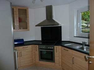 a kitchen with a stove top oven next to a window at Ferienwohnung Seyser in Gottmadingen
