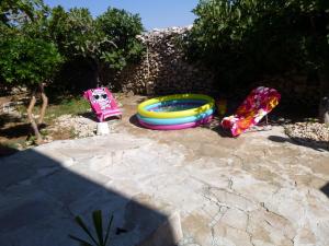 a backyard with a toy swimming pool and toy cars at Apartments KraljicaMira in Splitska