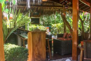 an outdoor patio with chairs and tables and trees at Vista Hermosa Bed and Breakfast in Tambor