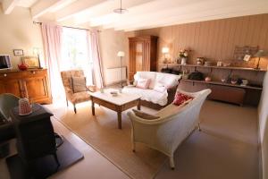 ein Wohnzimmer mit Sofa, Stühlen und einem Tisch in der Unterkunft La maison d'Alcime in Plumergat
