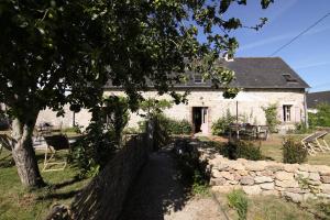 ein weißes Backsteinhaus mit einem Baum und einem Zaun in der Unterkunft La maison d'Alcime in Plumergat