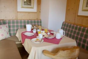 a table with a plate of food on it at Pension Sonnhof in Brixen im Thale
