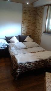 a bedroom with two beds and a brick wall at Apartament U Janusza in Nowy Targ