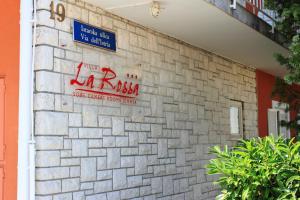 a brick building with a sign on the side of it at Bed and Breakfast La Rossa in Umag