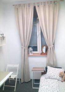 克拉科夫的住宿－Master Corner Apartment，一间卧室配有床和带窗帘的窗户