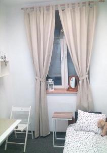 a bedroom with a bed and a window with curtains at Master Corner Apartment in Krakow