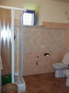 a bathroom with a toilet and a glass shower at Il Mulino in Maremma in Farnese