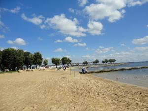 a beach with people walking on the sand and a pier at Apartament Relax in Giżycko