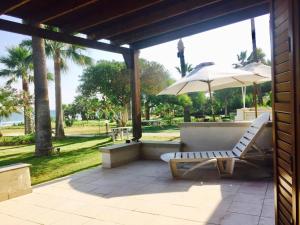 a patio with a white chair and an umbrella at Sandy Beach Villas 17 in Pyla