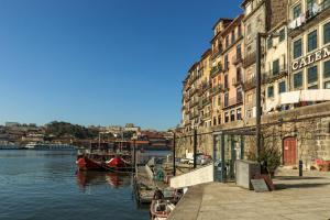 un groupe de bâtiments à côté d'une rivière avec des bateaux dans l'établissement Go2oporto - Ribeira do Porto, à Porto