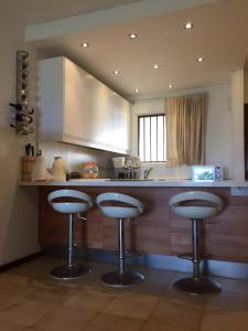 a kitchen with two bar stools at a counter at Sandy Beach Villas 17 in Pyla +6 photos
