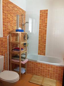 Sandy Beach Villas 17 في بيلا: حمام مع حوض استحمام ومرحاض