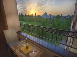 a table with a bottle of wine on a balcony at Apartman Banja Luka in Banja Luka